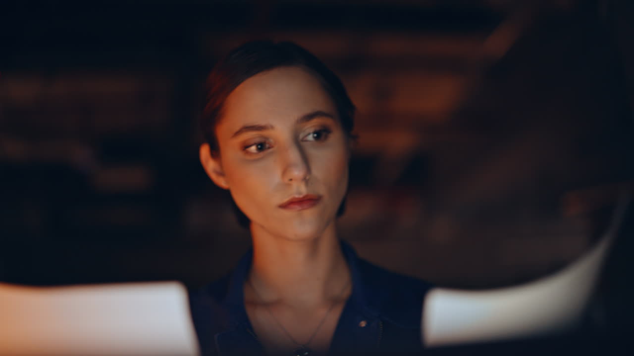 Closeup freelancer browsing laptop at night apartment. Portrait businesswoman