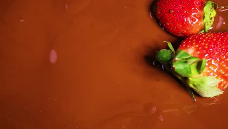 strawberries being dipped into melted chocolate