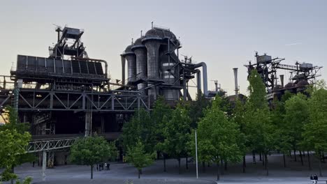 Sitio-Histórico-De-La-Fábrica-En-Un-Hermoso-Ambiente-Con-árboles-Y-Tuberías-Y-Líneas-Y-Grandes-Silos-Del-Parque-Paisajístico-En-El-Norte-De-Duisburg,-Alemania