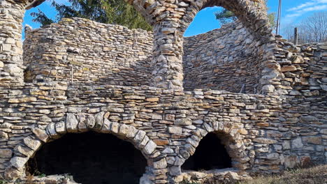 Vista-Panorámica-De-Una-Casa-De-Piedra-Abandonada-Y-Dañada-En-La-Naturaleza,-Inclinada-Hacia-La-Derecha