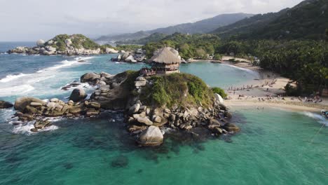 Tourist-lookout-point-shack-on-rocky-hill-above-crystal-clear-blue-water-in-Tayrona-National-Park-Colombia