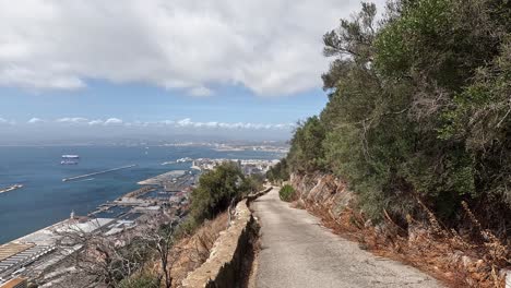 view over an old road leading down the rock of gibraltar. offering beautiful views on the ocean and city skyline