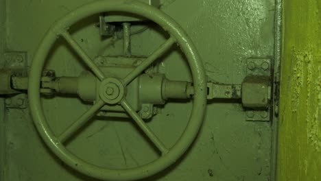 steel door lock inside the concrete bomb shelter to hide civil people, an underground apocalypse bunker built in old coastal fortification, medium handheld closeup dolly shot moving left