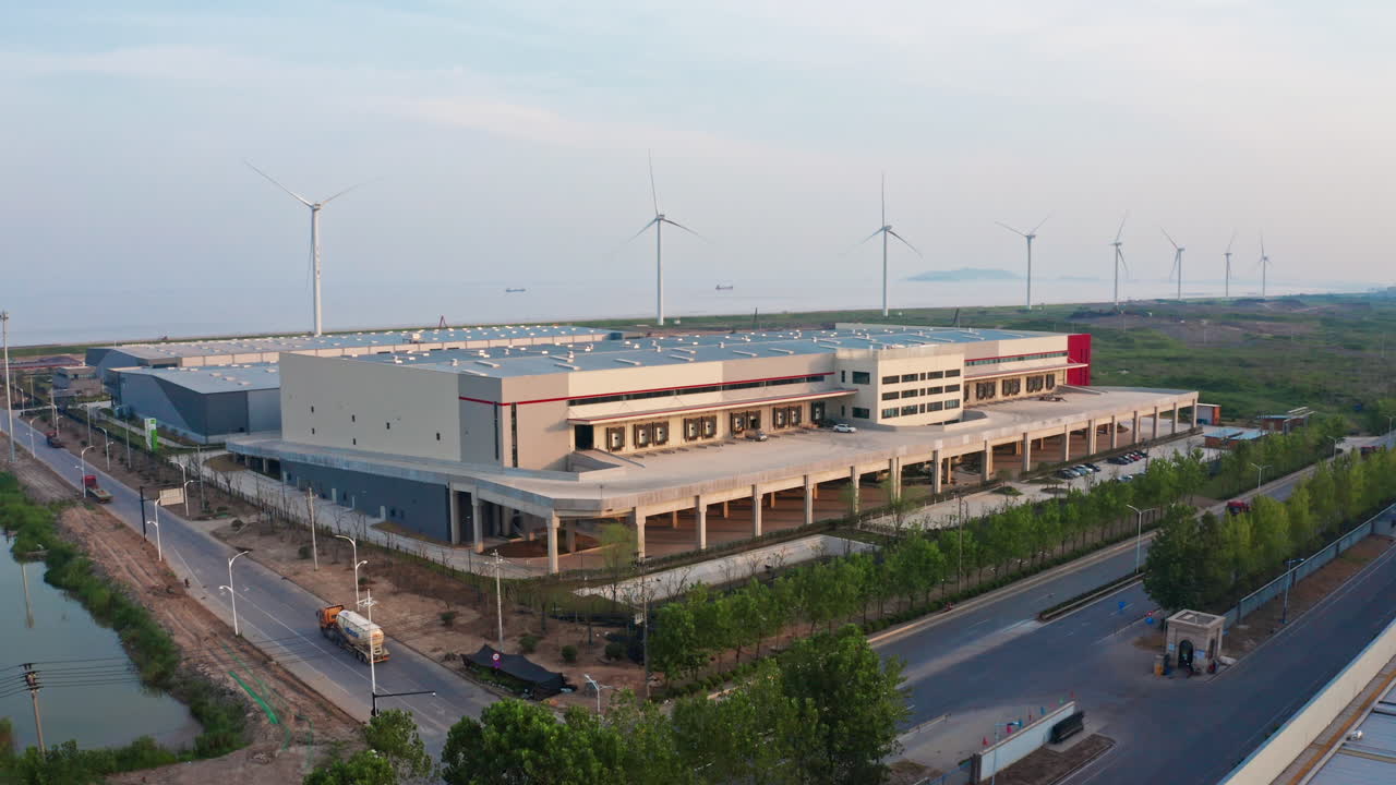 disparo aéreo girando alrededor del almacén de distribución con molinos de viento en el fondo