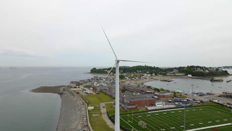 aerial slow motion reverse footage of wind turbine and football field in hull ma