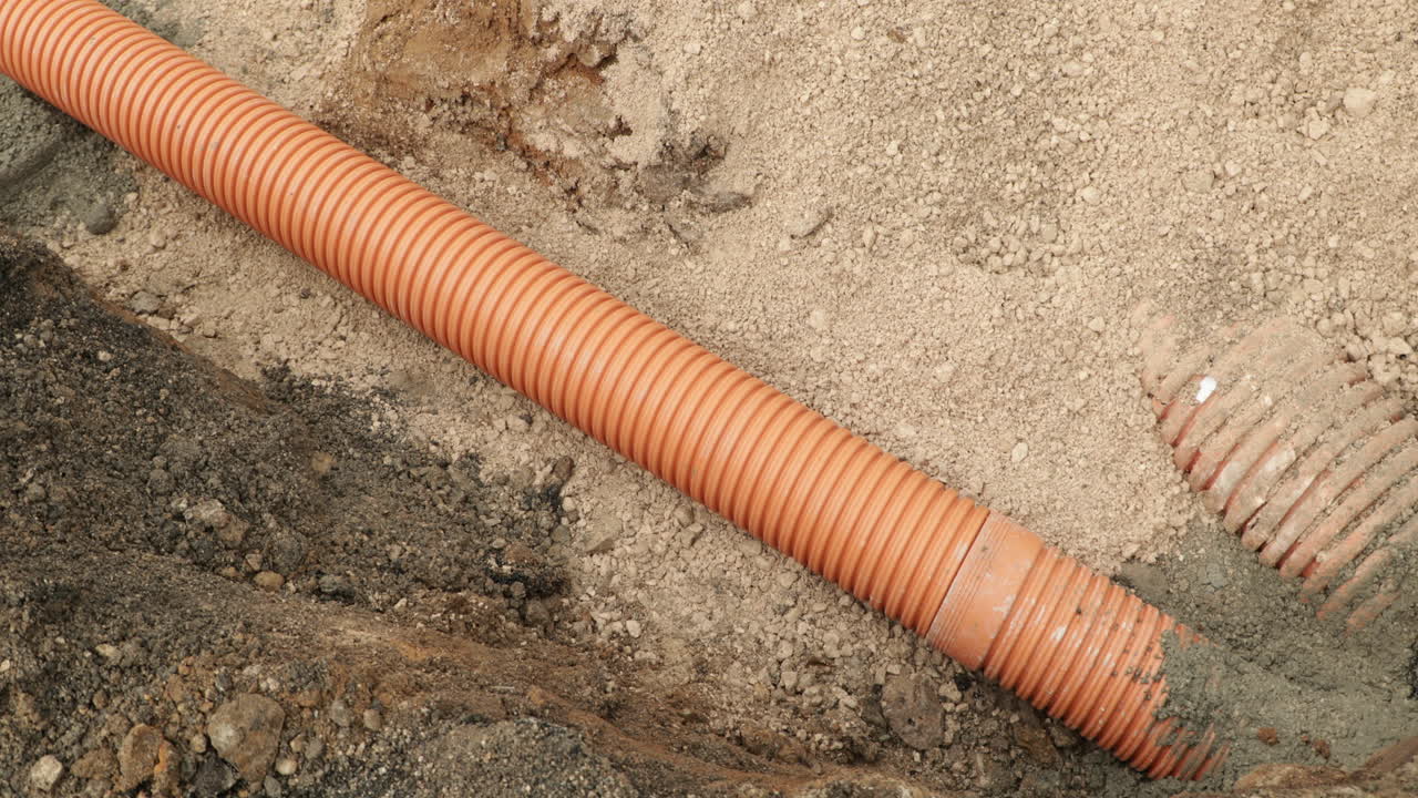 tubos de pvc naranja durante la instalación de una línea de alcantarillado en un pueblo de leiria, portugal
