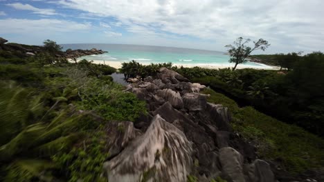 Fpv-drone-flying-on-a-beach-in-Seychelles-on-an-Island-Mahe,-video-of-incredible-trees,-Seychelles-rocks,-seaside,-and-surrounding-Seychelles-landscapes