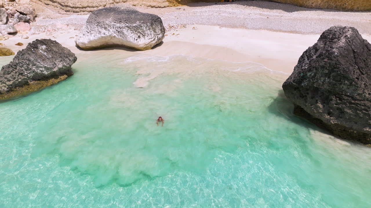 Woman Running To The Ocean To Swim In The Crystal Clear Water Of Shoab In Socotra Island, Yemen. - aerial shot