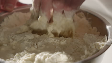 mixing flour and water by hand to make dough for bread or pizza dough 4k close up