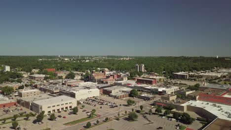 Downtown-suburban-Manhattan-buildings-and-skyline-on-sunny-day,-Kansas,-aerial-sideways