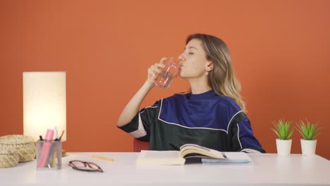 la joven está bebiendo agua.