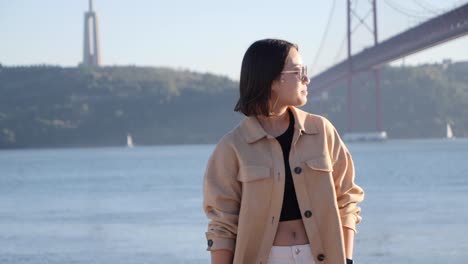 beautiful woman swings hair and enjoys the view of landmarks in lisbon, portugal