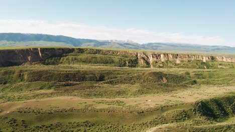 los picos de las montañas y las praderas están bajo nubes blancas.