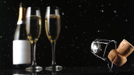 animation of cork falling over champagne bottle and glasses on black background