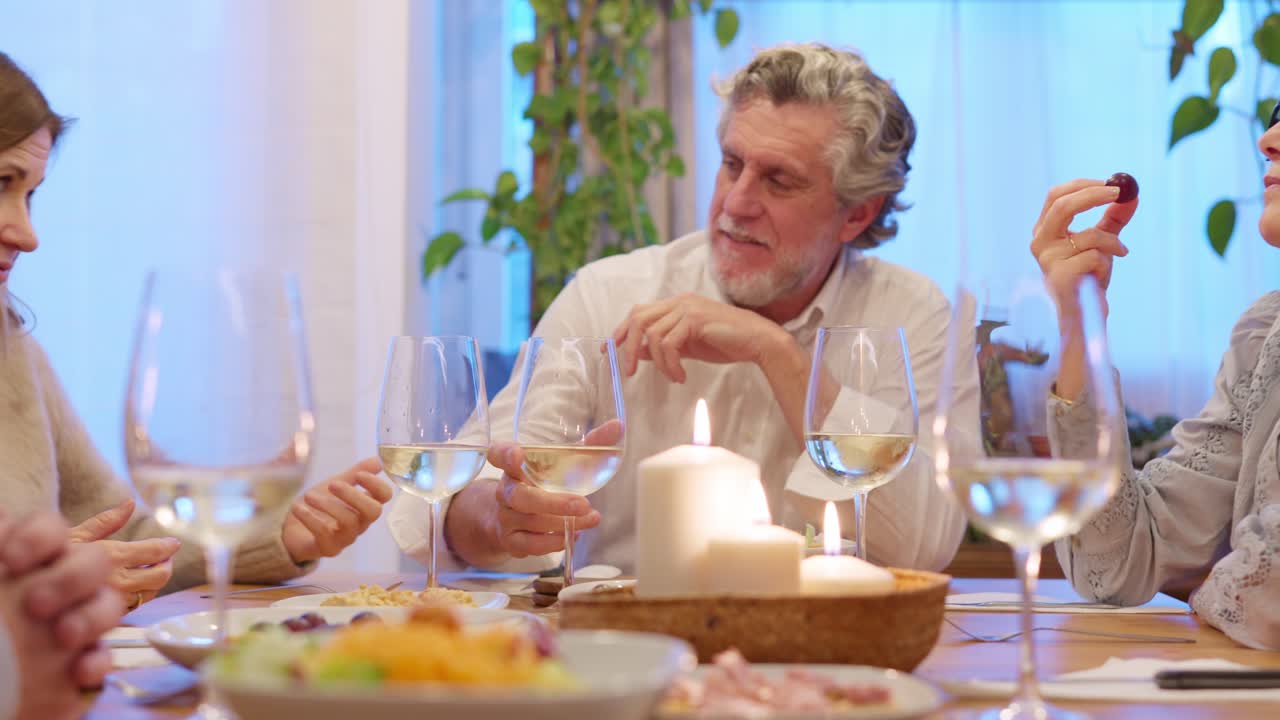 Amici maturi che si godono una cena e una conversazione in un incontro accogliente