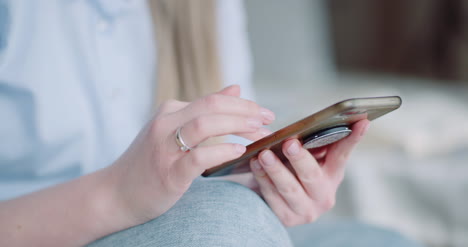 Happy-Woman-Browsing-Smartphone-At-Home-5