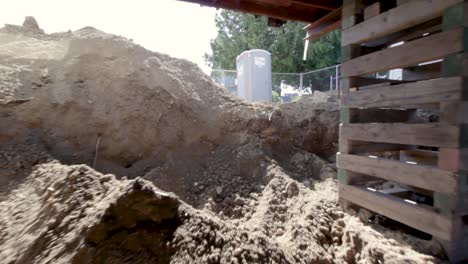 excavated soil on the foundation of a house construction site with sun flare and bokeh camera effect - dolly shot