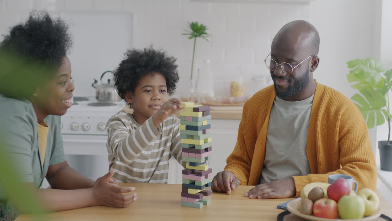 Family enjoying a game of stacking wooden blocks in the kitchen