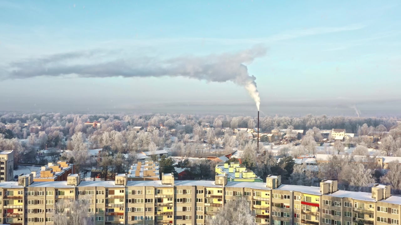 Cold winter morning with snow-covered trees and residential buildings on a sunny day