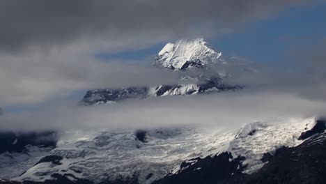 Zooming-out-from-the-Mount-Fairweather-Range-between-the-low-clouds,landscape-with-Johns-Hopkins-Glacier-in-Glacier-Bay-National-Park,-Alaska