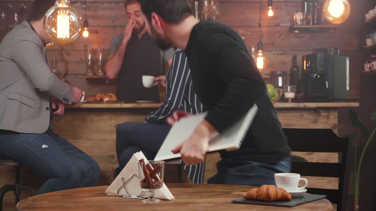 People working and socializing in a cozy cafe with warm lighting