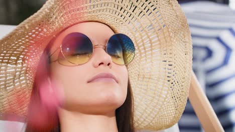 Close-up-video-of-woman-in-sunglasses-relaxing-on-the-beach