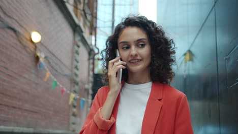 woman talking on phone in a city alley