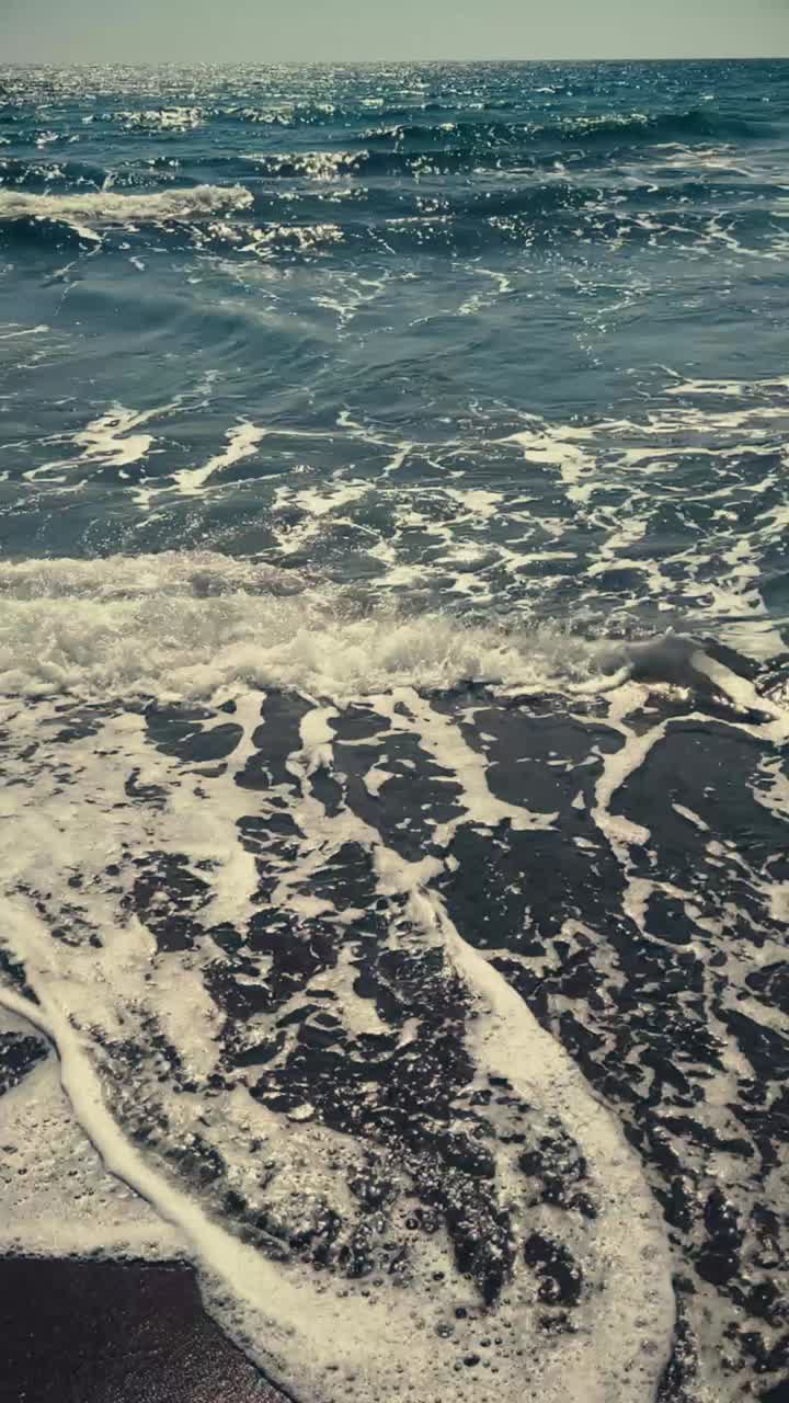 Gentle Ocean Waves Crashing on a Dark Sandy Beach
