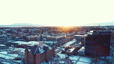 provo city center temple aerial during sunset sunrise with a bright orange sun flare over the city of provo utah