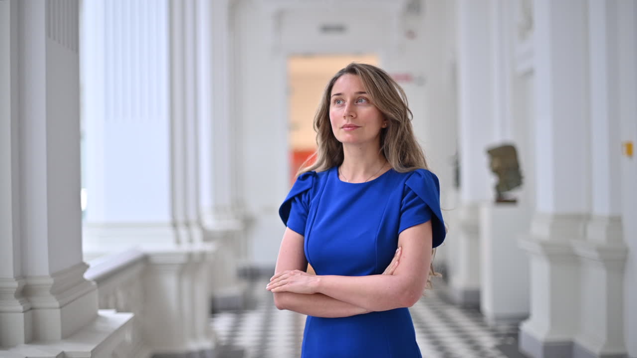 Donna bruna in abito blu che si muove nel Museo nazionale di belle arti di Chișinău, Moldavia