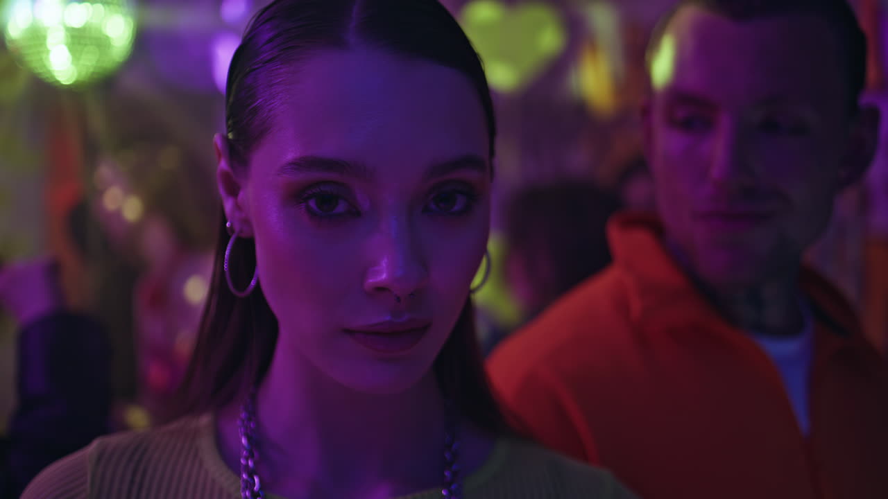 Glamorous clubber looking camera under disco ball glow closeup. Portrait woman