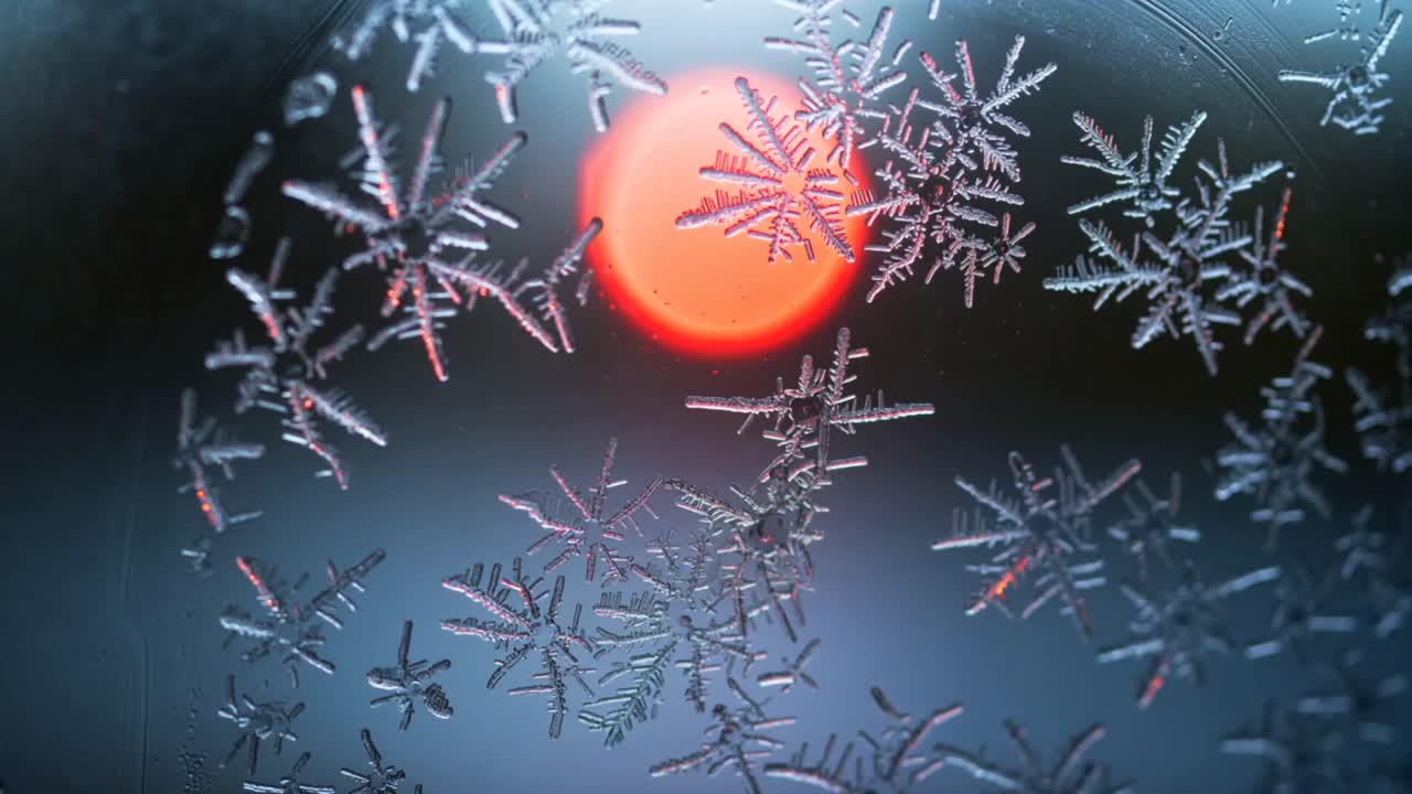 Bokeh rosso brillante che crea un gruppo di cristalli di ghiaccio che cattura i riflessi su un vetro, mettendone in risalto la forma