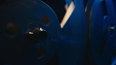 a vintage tape recorder spinning spools in a blue light