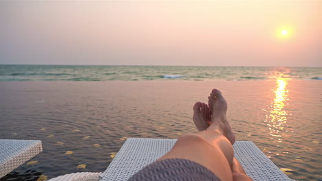 POV-Von-Einer-Sonnenliege-Am-Rand-Eines-Resort-Pools-Mit-Blick-Auf-Das-Meer-Und-Den-Sonnenuntergang