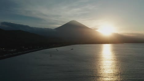 silhouette of mount agung volcano during sunset, bali shore, aerial