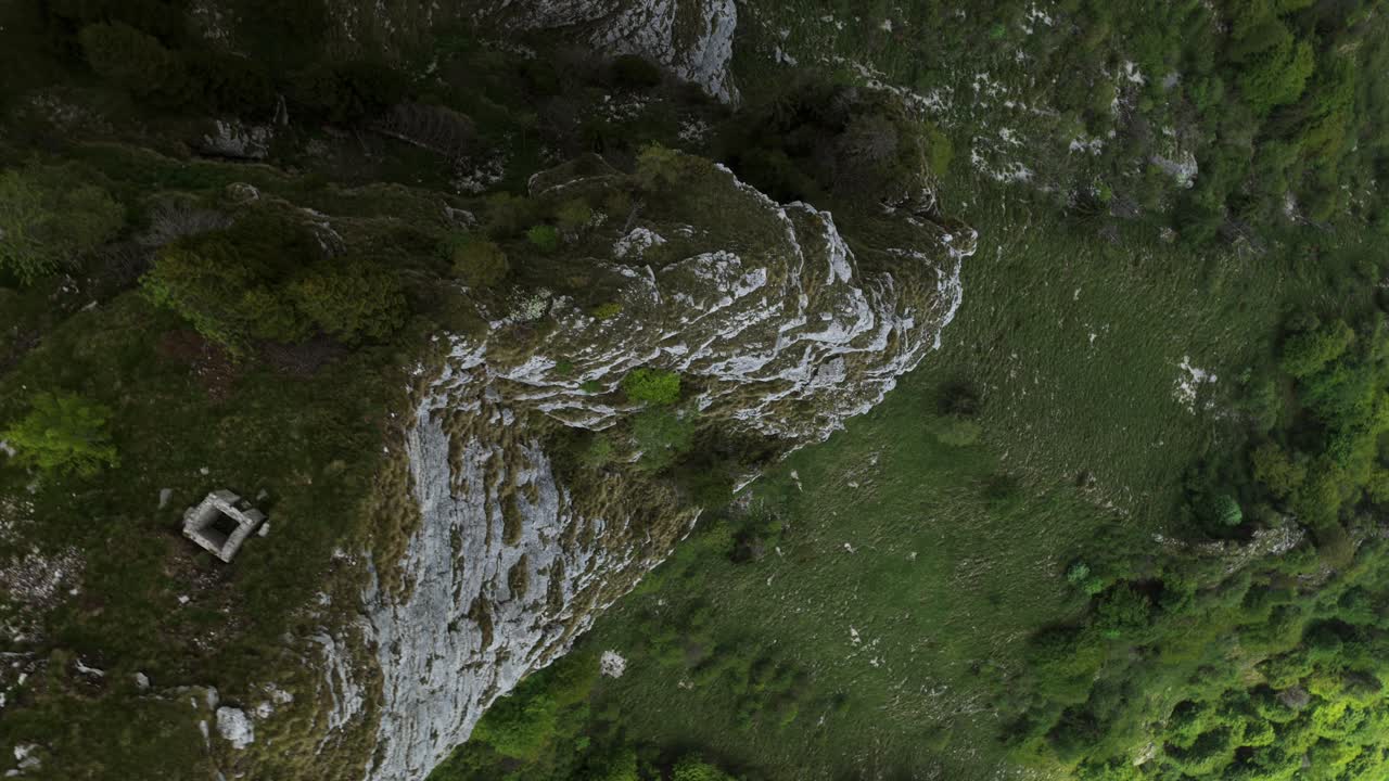Forte Campolongo, green alpine meadows and forest, Asiago Plateau, Italy. Aerial top-down ascending