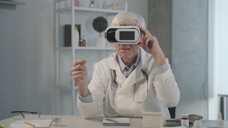 un médico de mediana edad, canoso, prueba y ajusta las gafas vr