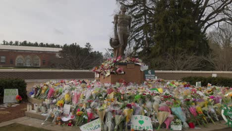 Estatua-Espartana-En-El-Campus-De-La-Universidad-Estatal-De-Michigan-Con-Flores-Después-Del-Tiroteo-Masivo-En-Febrero-De-2023-Con-Video-Cardán-Caminando-De-Lado