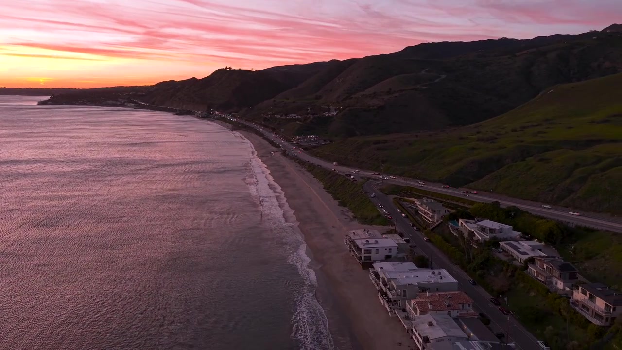 Tramonto a Malibu lungo la spiaggia costiera in brillanti colori oro rosa. Guida sulla Pacific Coast Highway attraverso la calda luce serale californiana all'iconica ora d'oro.