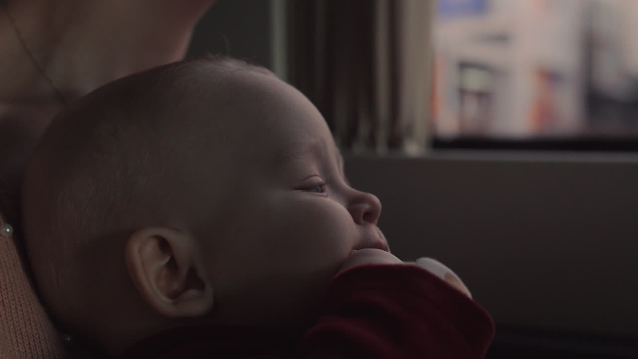 입에 손을 고 있는 6개월 된 아기 소녀