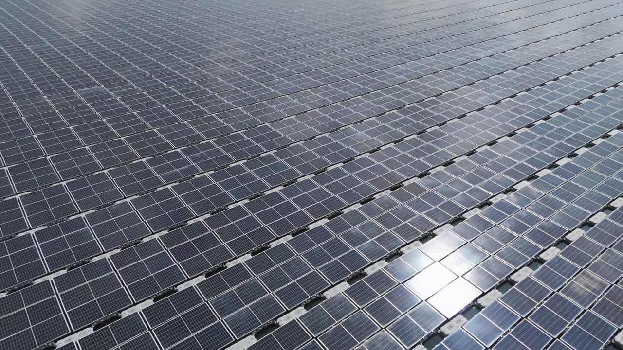 Una vista aerea del più grande impianto solare galleggiante della Malesia su Danau Tok Uban, Kelantan, che mostra il modello a griglia geometrica dei pannelli solari sulla superficie dell'acqua.