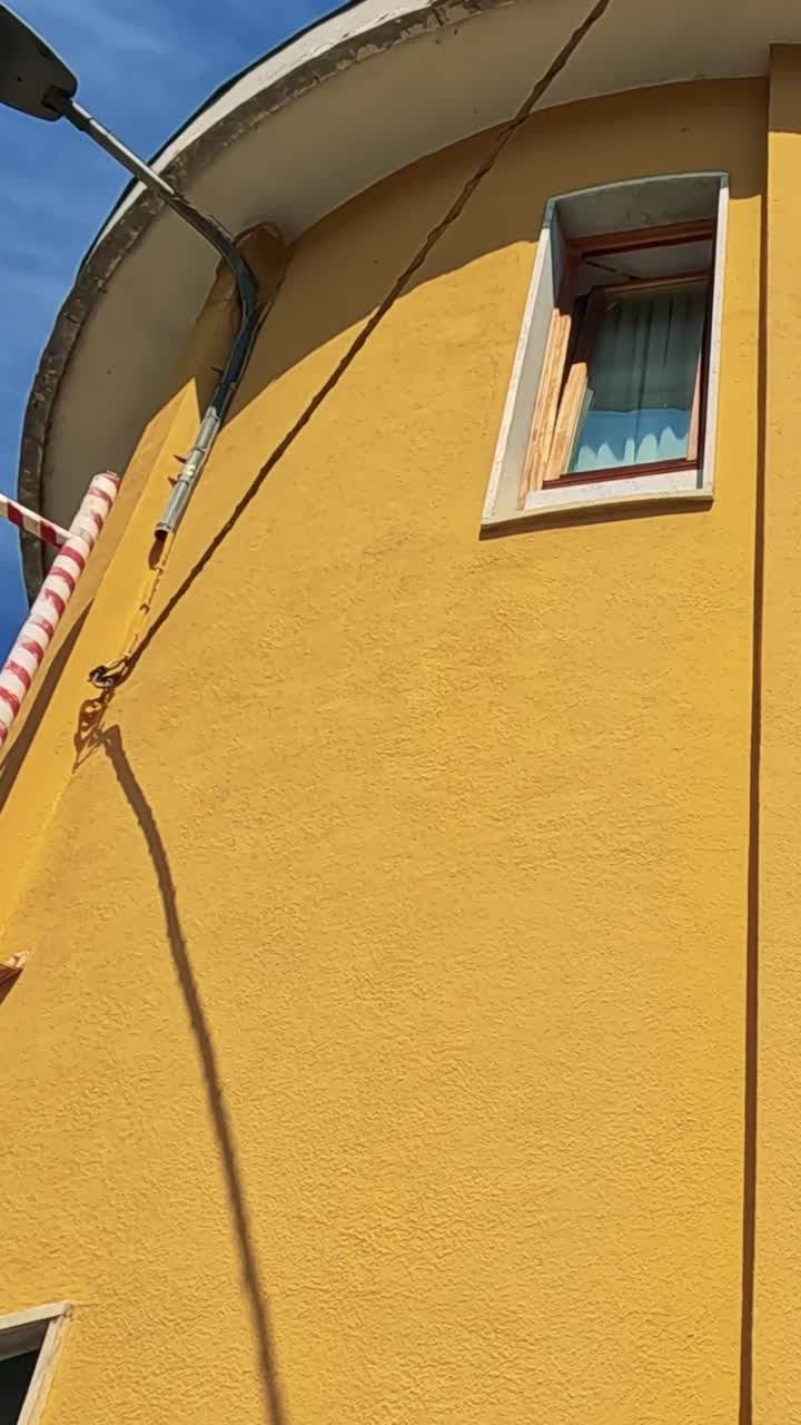 edificio amarillo con letrero y cielo azul