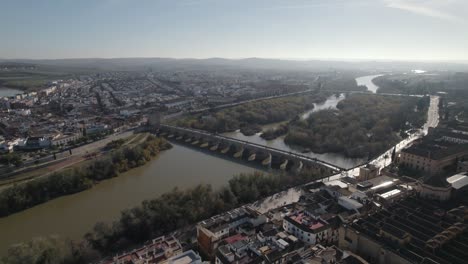 aerial view cityscape of cordoba with roman bridge over the guadalquivir river, bright sunlight