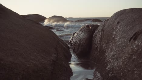 rough waves crashing into rocks on a windy day in langebaan, cape town