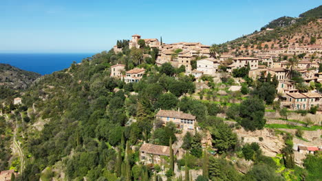 Dramatic-aerial-flyover-of-historic-Deia-Village-Mallorca-on-hot-summer-day