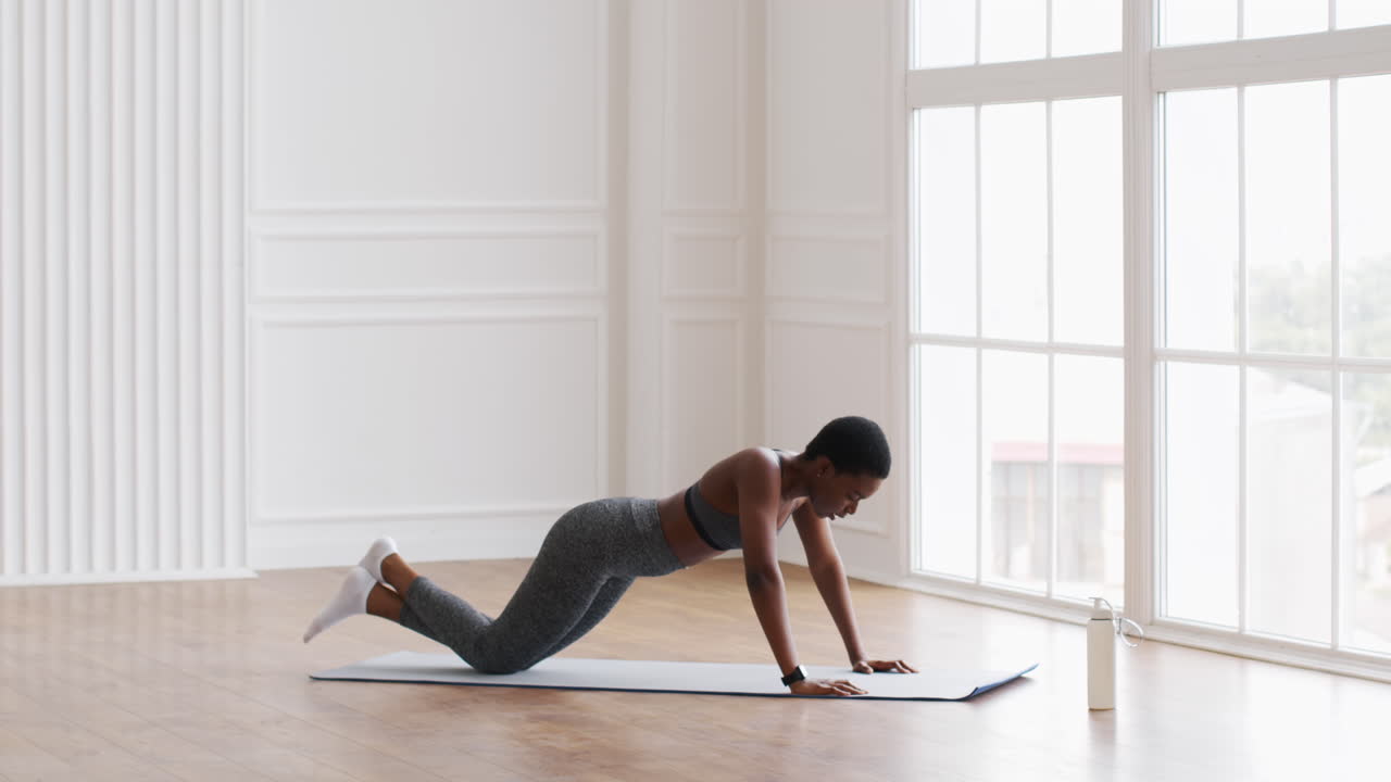 mujer haciendo flexiones en la alfombra de ejercicio
