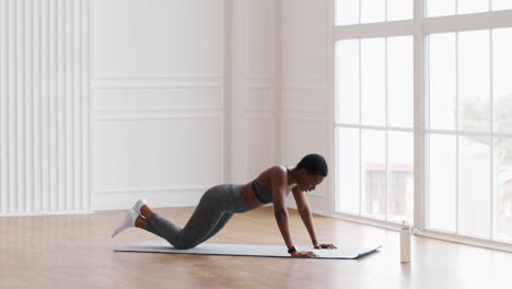 mujer haciendo flexiones en la alfombra de ejercicio