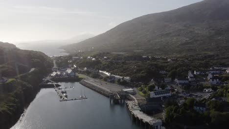 dynamic drone shot of the village of tarbert on a sunny day, featuring the isle of harris distillery