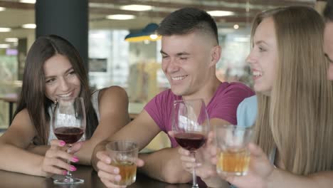 amigos se sientan en un bar y beben alcohol