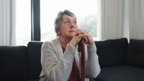 Cane,-support-and-thinking-with-old-woman-on-sofa